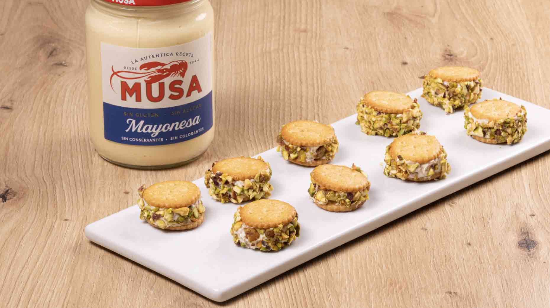 Canapés de atún y pistachos elaborados con queso crema y Mayonesa Musa, decorados con pistachos picados.
